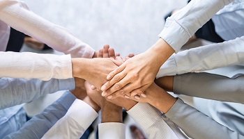 group with hands together in center