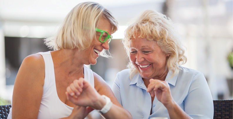 two senior women laughing together