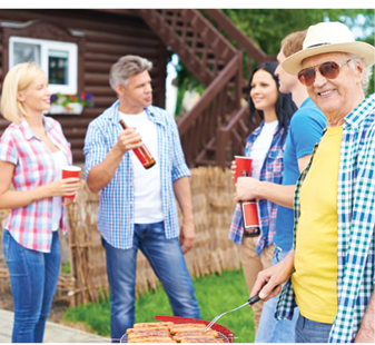 group of adults dressed in casual clothing talking during cookout outdoors