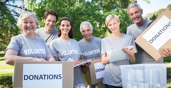 diverse group of male and female volunteers holding donation boxes