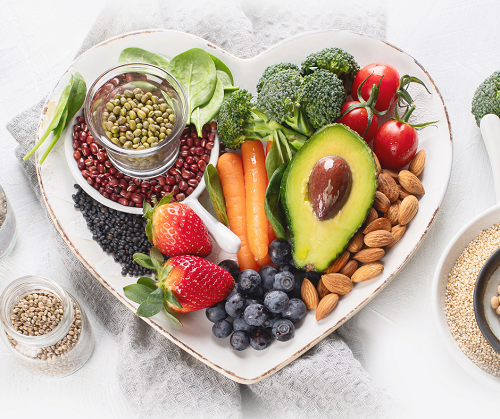 mix of fruits, veggies, and nuts displayed on a heart shaped plate