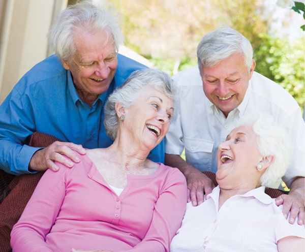 Group of older-adult couples laughing together outdoors